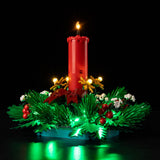 Low side view of Christmas Table Decoration 40743 with illuminated candle and green wreath