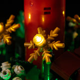 Warm yellow light in a gold snowflake beside the red candle on Christmas Table Decoration 40743